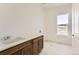 Bright laundry room featuring a large window, tile floors and a countertop with cabinets at 483 Agoseris Way, Castle Rock, CO 80104