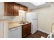 Efficient kitchen features a double sink, white refrigerator, and warm wood cabinets at 14454 E Colorado Dr # 102, Aurora, CO 80012