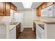 Efficient kitchen with stainless steel sink, white appliances, and warm wood cabinets at 14454 E Colorado Dr # 102, Aurora, CO 80012