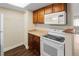 The kitchen area features a white microwave and stove with wood cabinets at 14454 E Colorado Dr # 102, Aurora, CO 80012