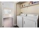 Bright laundry room with washer, dryer, and storage shelf at 14454 E Colorado Dr # 102, Aurora, CO 80012