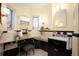 Stylish bathroom featuring black and cream tiles, a vanity with mirror, and natural light from the windows at 6 Ivy Ln, Denver, CO 80220