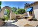 Picturesque courtyard featuring a curved wall, ornate gate, and comfortable seating area surrounded by lush greenery at 6 Ivy Ln, Denver, CO 80220