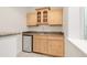 Basement bar area with wood cabinets, countertop, sink, and beverage cooler at 6246 W 35Th Ave, Wheat Ridge, CO 80033