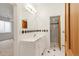 Bathroom featuring classic black and white tile accents, shower, sink and wood-look doors at 6246 W 35Th Ave, Wheat Ridge, CO 80033