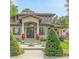 Elegant home featuring a symmetrical design, red urns, and a well-manicured lawn with trimmed bushes at 6246 W 35Th Ave, Wheat Ridge, CO 80033