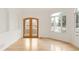 Bright room featuring hardwood floors, a balcony, and a large window, ideal for a sun-soaked retreat at 6246 W 35Th Ave, Wheat Ridge, CO 80033