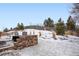 Stone retaining wall and snowy backyard with a wood fence at 17395 Leisure Lake Dr, Monument, CO 80132