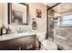 Bathroom featuring walk-in shower with tiled walls, granite vanity, contemporary fixtures, and decorative framed art at 1488 W 102Nd Ave, Northglenn, CO 80260