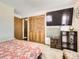 Bedroom featuring carpet floors, closet with bi-fold doors, TV and decorative shelving at 1488 W 102Nd Ave, Northglenn, CO 80260