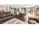 Open-concept living room with a spacious kitchen island, stainless steel appliances and hardwood floors at 1488 W 102Nd Ave, Northglenn, CO 80260