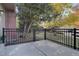 Private patio with metal railing, trees, and grassy area at 112 S Holman Way, Golden, CO 80401