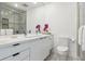 Well-lit bathroom with double sinks, vanity storage, a modern toilet, and glass enclosed shower at 1201 N Williams St # 3A, Denver, CO 80218