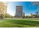 An attractive exterior view of the building surrounded by trees, a green lawn and bright blue skies at 1201 N Williams St # 3A, Denver, CO 80218