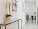 Modern hallway with sleek console table, white walls, and neutral tile flooring at 1201 N Williams St # 3A, Denver, CO 80218