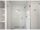 A tiled shower with glass enclosure, gray hexagon floor and tiled shelving at 1035 S Garfield St, Denver, CO 80209