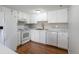 Bright kitchen features white cabinetry, modern appliances, and stylish countertops and a dark wooden floor at 12743 Eudora Dr, Thornton, CO 80241