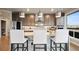 Bright kitchen featuring a gray island with white chairs and modern lighting fixtures over granite counter tops at 20 Wilcox St # 302, Castle Rock, CO 80104