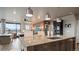 Open concept kitchen with seating, an island, modern cabinets, and stainless steel dishwasher in a modern condo at 20 Wilcox St # 302, Castle Rock, CO 80104