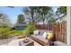 Cozy backyard with a wicker sofa, decorative pillows, and a serene outdoor seating area at 2353 S Jamaica St, Aurora, CO 80014