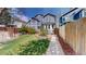 Beautifully landscaped backyard with lush lawn, a charming brick-lined garden bed, and privacy fence at 2353 S Jamaica St, Aurora, CO 80014
