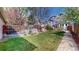 Well-maintained backyard featuring a grassy lawn, mature trees, and a wooden privacy fence at 2353 S Jamaica St, Aurora, CO 80014