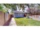 Lush backyard featuring a well-manicured lawn, mature trees, and a charming detached garage at 2353 S Jamaica St, Aurora, CO 80014