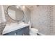 Stylish powder room featuring a modern vanity, round mirror and black and white patterned wallpaper at 2353 S Jamaica St, Aurora, CO 80014