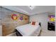 Charming bedroom showcasing a rustic wood accent wall with fun cartoon monkey art at 2353 S Jamaica St, Aurora, CO 80014