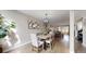 Bright dining area with a modern chandelier, light wood floors, and seamless transition to the living room at 2353 S Jamaica St, Aurora, CO 80014