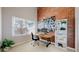 Bright home office with an exposed brick wall, large window, and shelving at 2353 S Jamaica St, Aurora, CO 80014