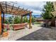 Backyard patio with brick pavers, wood pergola, seating area, and landscaping at 6963 E Heritage S Pl, Centennial, CO 80111