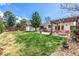 Spacious backyard with a lush green lawn, storage shed, and a cozy pergola-covered seating area at 6963 E Heritage S Pl, Centennial, CO 80111