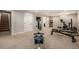 Finished basement with carpet and home gym, featuring a rowing machine, elliptical, and weight bench at 6963 E Heritage S Pl, Centennial, CO 80111