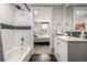 Bathroom with a shower, white subway tile with black accents, white vanity, and bedroom view at 6963 E Heritage S Pl, Centennial, CO 80111