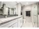 Modern bathroom featuring double sinks, marble countertops, and a glass shower at 6963 E Heritage S Pl, Centennial, CO 80111