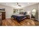 Serene bedroom with hardwood floors, large windows, ceiling fan, and comfortable queen-size bed at 6963 E Heritage S Pl, Centennial, CO 80111