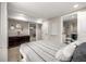 Bedroom with neutral walls, black bedframe with gray-striped bedding, and a bathroom nearby at 6963 E Heritage S Pl, Centennial, CO 80111