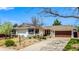 Charming single-story home featuring a well-manicured front yard, brown roof, and a two-car garage at 6963 E Heritage S Pl, Centennial, CO 80111