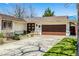 Charming single-story home with well-manicured front yard, brown roof, and an attached two-car garage at 6963 E Heritage S Pl, Centennial, CO 80111