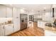 Open kitchen featuring stainless steel appliances, granite countertops, white cabinetry, and hardwood floors at 6963 E Heritage S Pl, Centennial, CO 80111