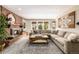 Cozy living room features a brick fireplace, large windows, and comfortable seating area at 6963 E Heritage S Pl, Centennial, CO 80111