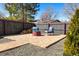 Cozy backyard patio with brick pavers, fire pit, seating, and a wood pile ready for a relaxing evening at 1835 S Poplar St, Denver, CO 80224