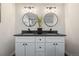 Bathroom features a dual sink vanity with round mirrors and modern lighting fixtures at 1835 S Poplar St, Denver, CO 80224
