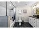 Bathroom with walk-in shower, tub, black hexagonal tile flooring, and white vanity with dark countertop at 1835 S Poplar St, Denver, CO 80224