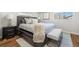 Bedroom with gray furnishings, wood floors, natural light from a window, and modern decor at 1835 S Poplar St, Denver, CO 80224