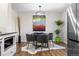 Modern dining area with a stylish light fixture, contemporary art, and a view into the updated kitchen at 1835 S Poplar St, Denver, CO 80224