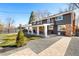 Back exterior view featuring a large yard, covered patio, and beautiful landscaping at 1835 S Poplar St, Denver, CO 80224