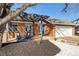 Attractive brick home featuring a pergola-covered porch, manicured landscaping, and an attached two-car garage at 1835 S Poplar St, Denver, CO 80224