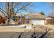 Charming single-story brick home with a pergola-covered patio, landscaped front yard, and attached garage at 1835 S Poplar St, Denver, CO 80224